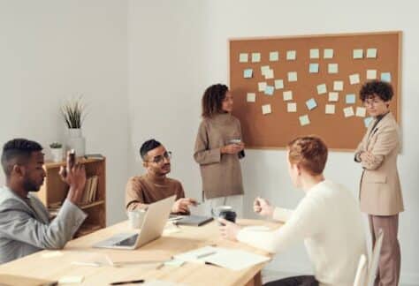 A diverse group of professionals collaborating in a modern office setting with a brainstorming session.