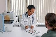 A doctor consulting with a patient in an office, discussing a medical chart.