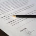 Close-up image of a business contract and pen, signed and ready for agreement.