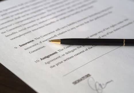 Close-up image of a business contract and pen, signed and ready for agreement.