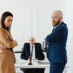 A couple in corporate attire seeks mediation during a business disagreement in an office setting.