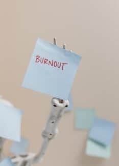 A skeleton holding a sticky note reading 'Burnout', symbolizing workplace stress.