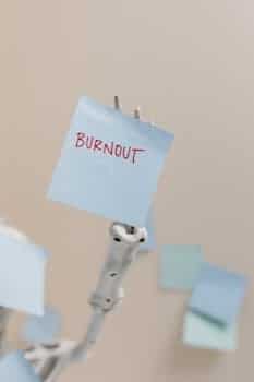 A skeleton holding a sticky note reading 'Burnout', symbolizing workplace stress.